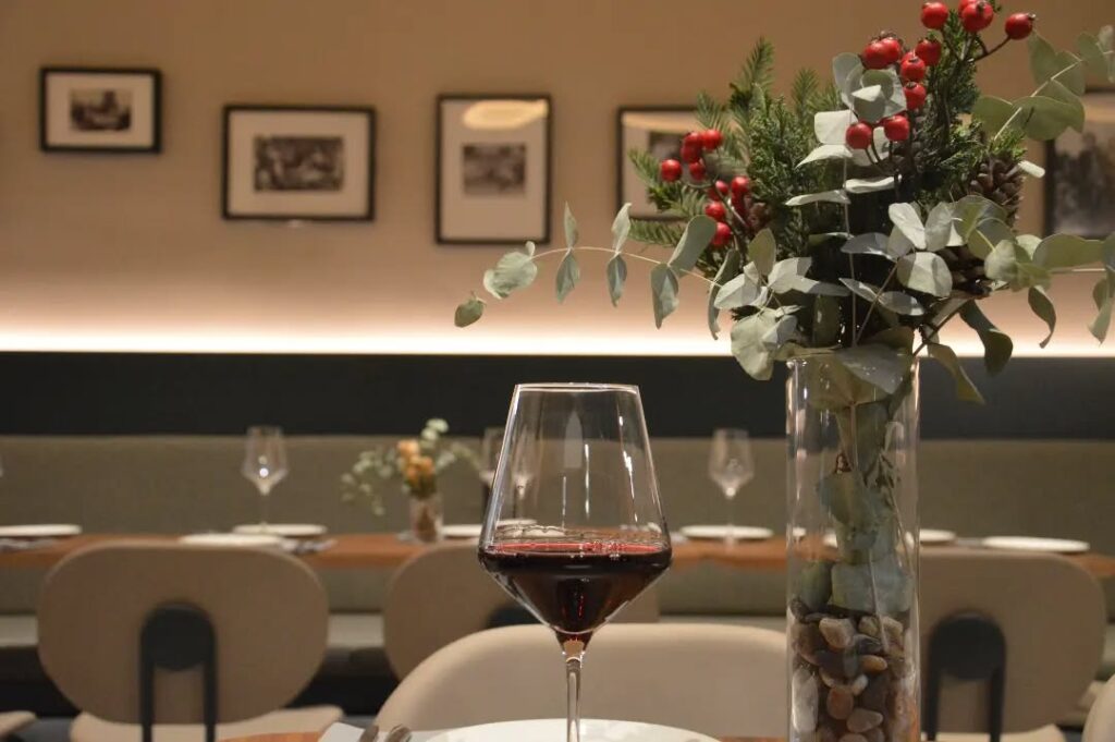 Foto del local con un primer plano de una copa de vino tinto